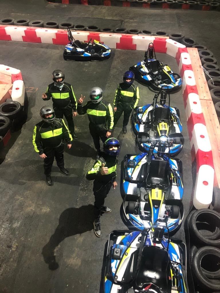 people in green and black racing suit riding blue and black sports bike